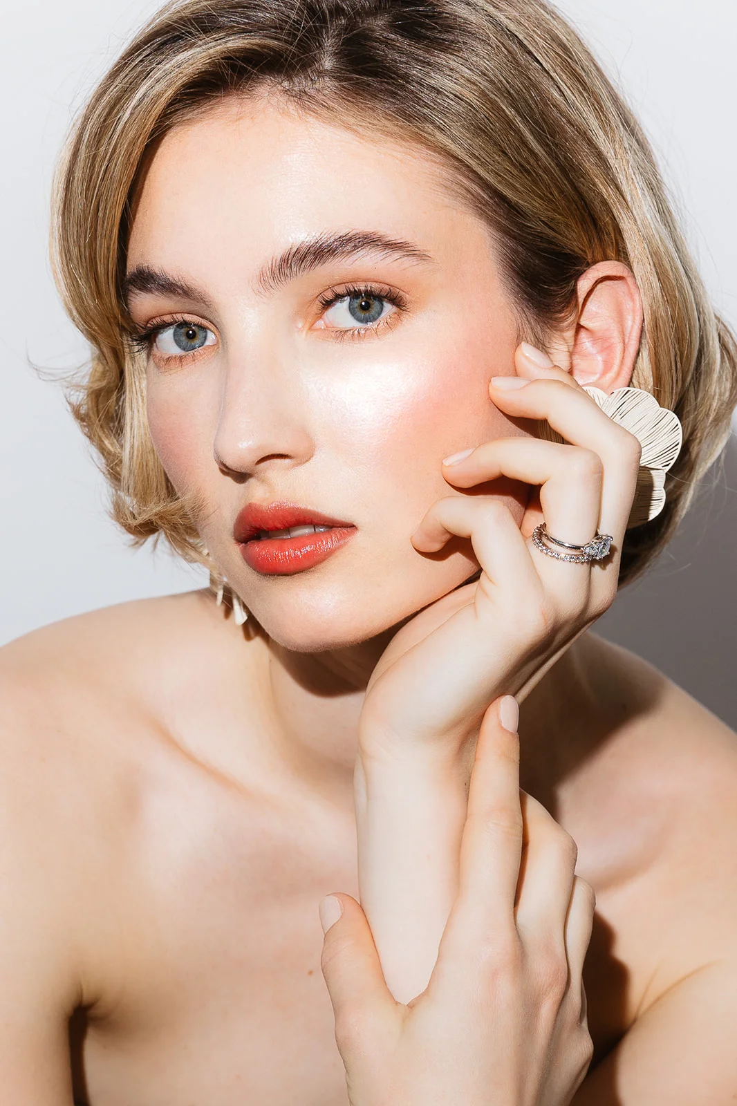 Braut mit weichem Make-up, die Hand am Gesicht